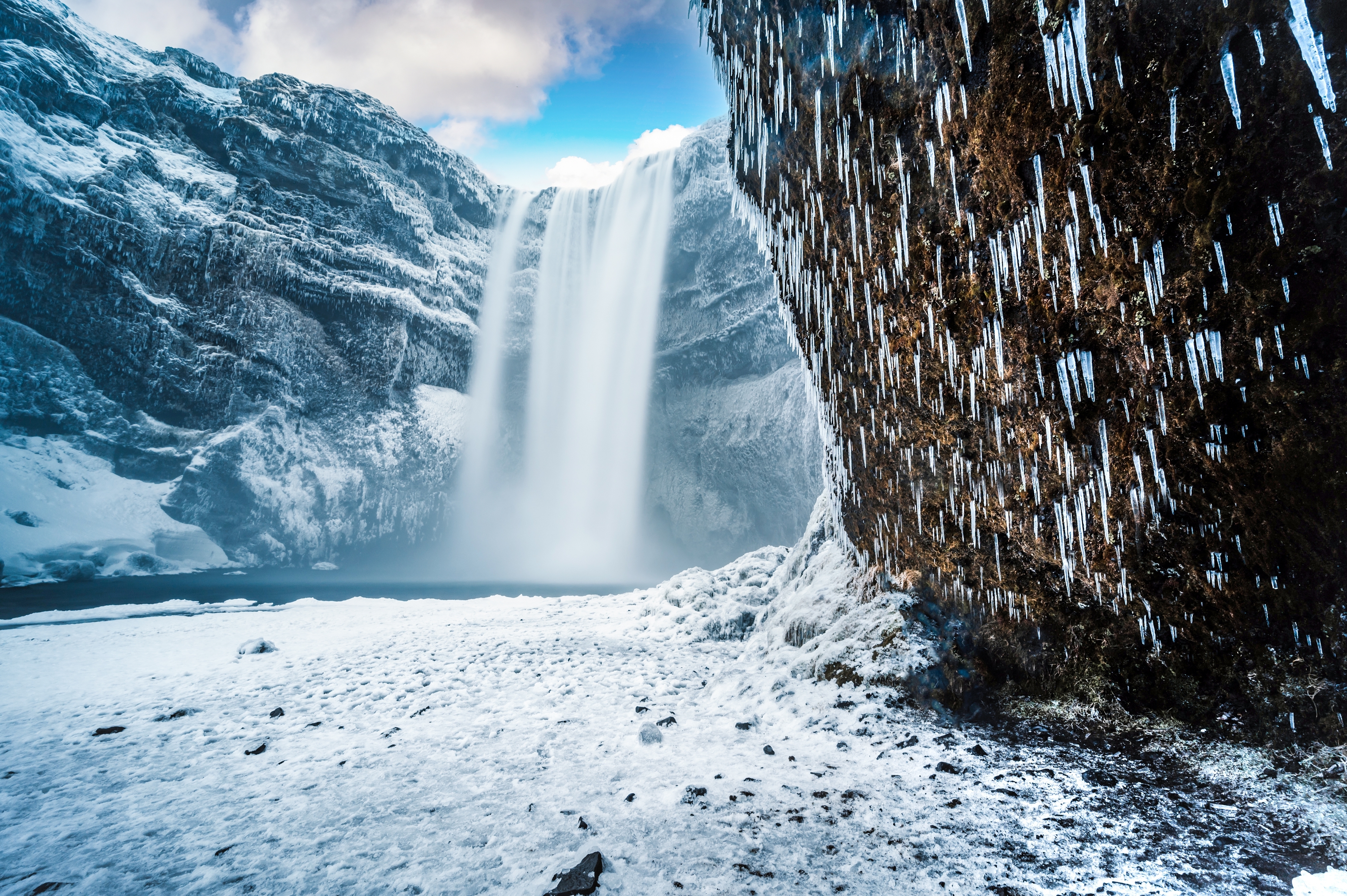 Skogafoss vandfald om vinteren med is-stalaktitter og snedækket islandsk landskab