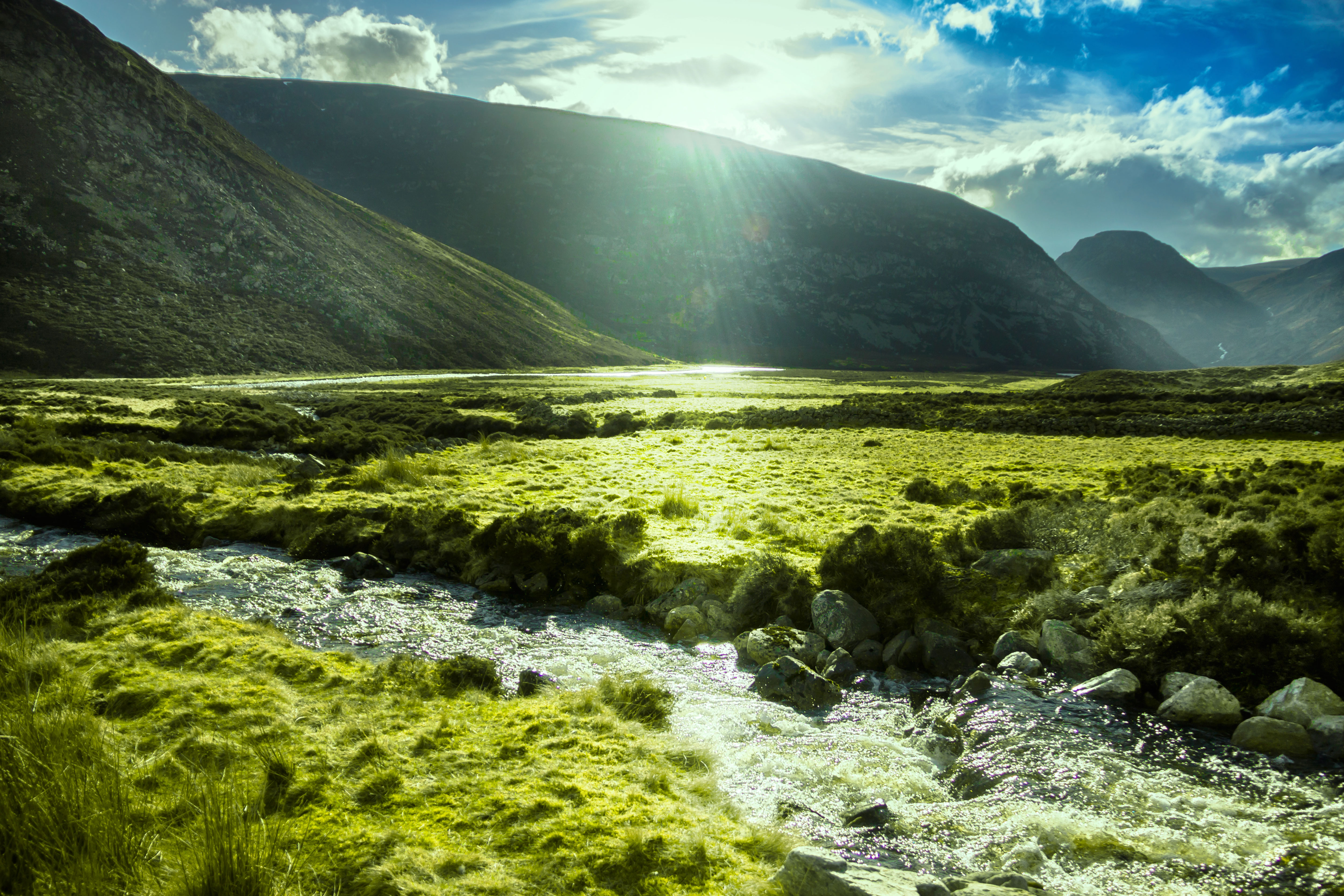 Smuk Highland dal med strømmende flod og grønne enge i Skotlands Cairngorms Nationalpark om sommeren