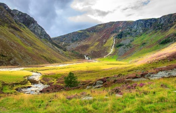 Smuk skotsk dal med vandfald og groenne enge i Cairngorms Nationalpark