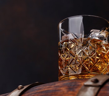 Traditionel skotsk whisky med is på rustik træfade ved Ben Nevis Destilleri, en del af Smil Rejsers rundtur i det skotske højland