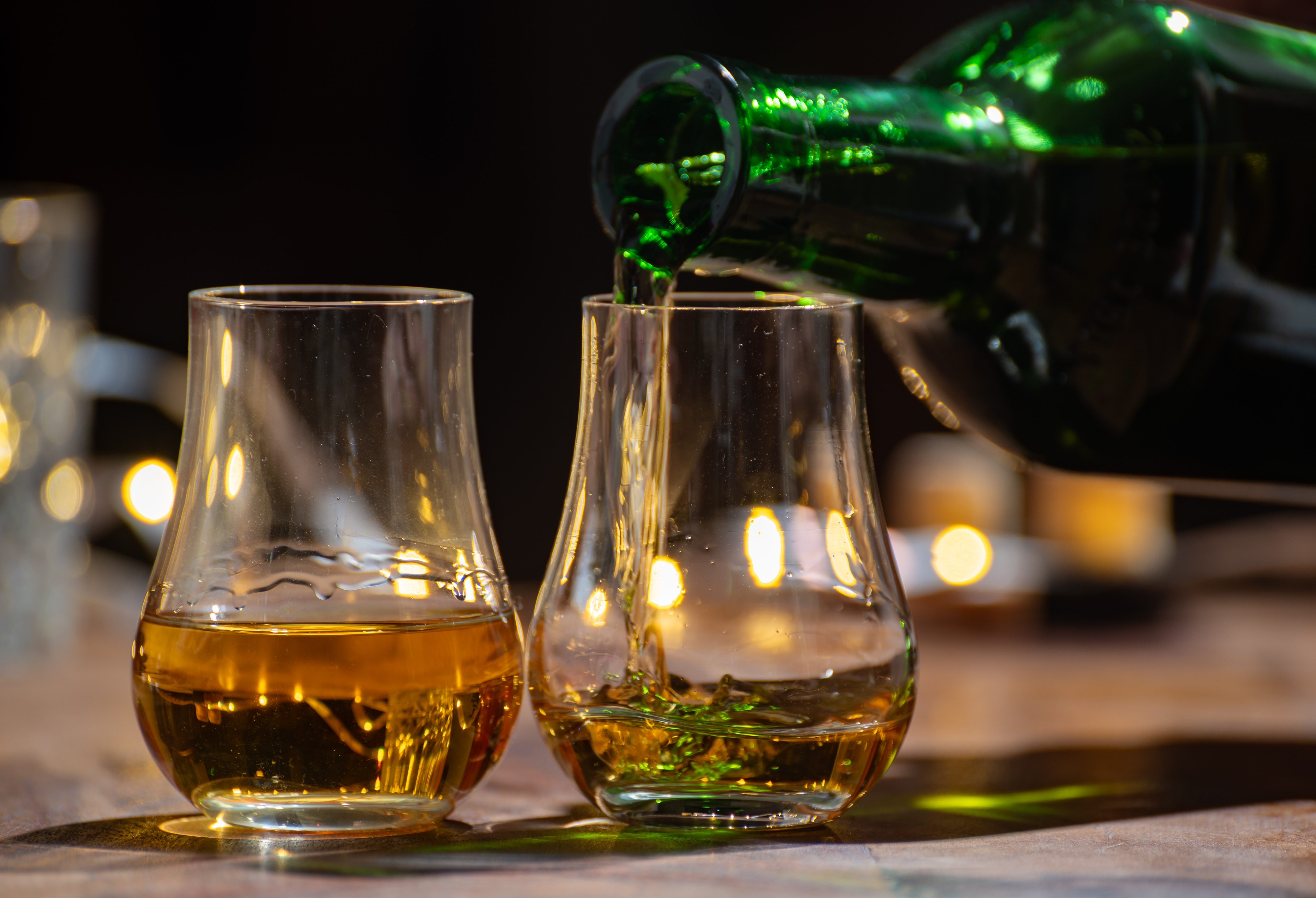 Skotsk whisky hældes i smageglas med stemningsfuld belysning