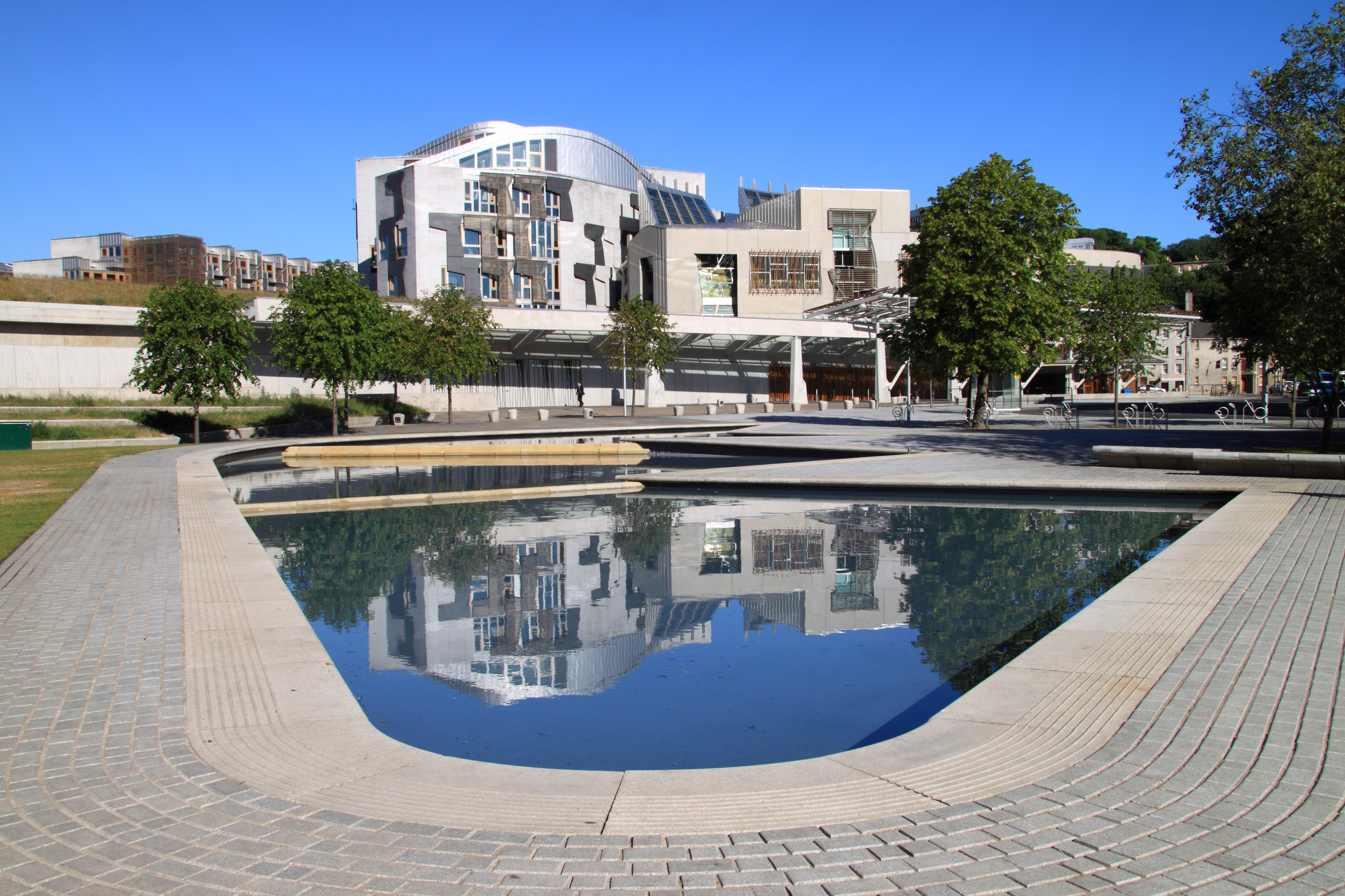 Det skotske parlament Holyrood i Edinburgh med moderne arkitektur og flot vandspejl foran den historiske bygning