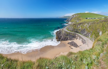 Idyllisk strand mellem Slea Head og Dunmore Head på Dingle-halvøen i Kerry, Irland med azurblåt vand og grønne klippefyldte kyster