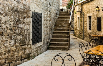 En smal gade i den historiske gamle bydel i Budva, Montenegro, med middelalderlig arkitektur og livlig kultur.