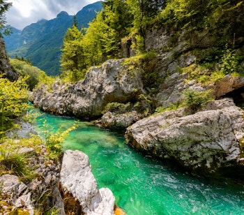 Smaragdfloden Soča i Slovenien med krystalklart turkisgrønt vand der løber gennem en malerisk canyon i Triglav Nationalpark