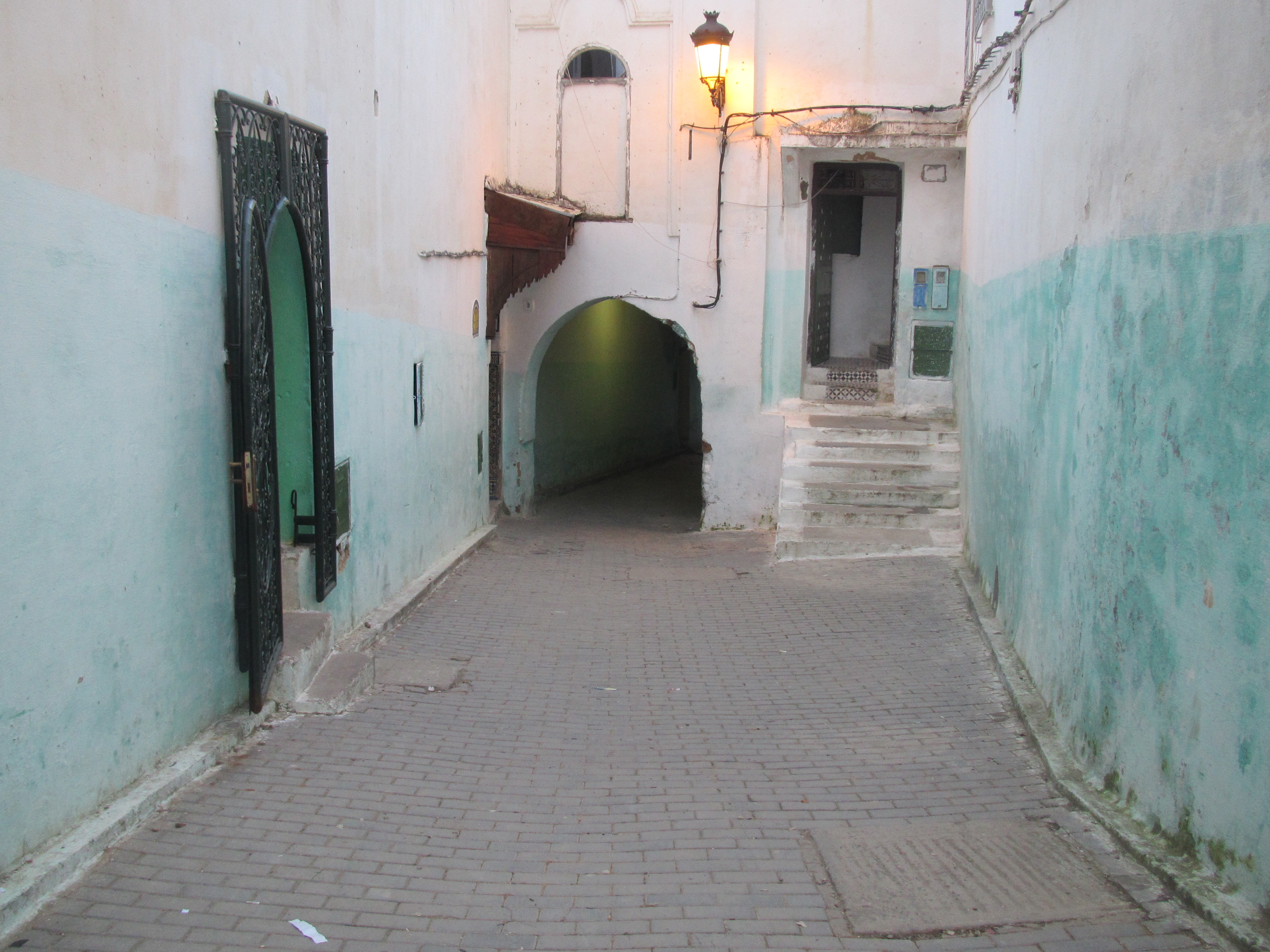 Charmerende smal gade med blå og hvide mure i historisk middelhavsby