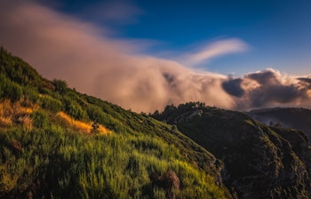 Betagende solnedgang over Curral das Freiras (Nonnernes Dal) på Madeira med landsbyhuse og bjerglandskab indhyllet i gyldent aftenlys