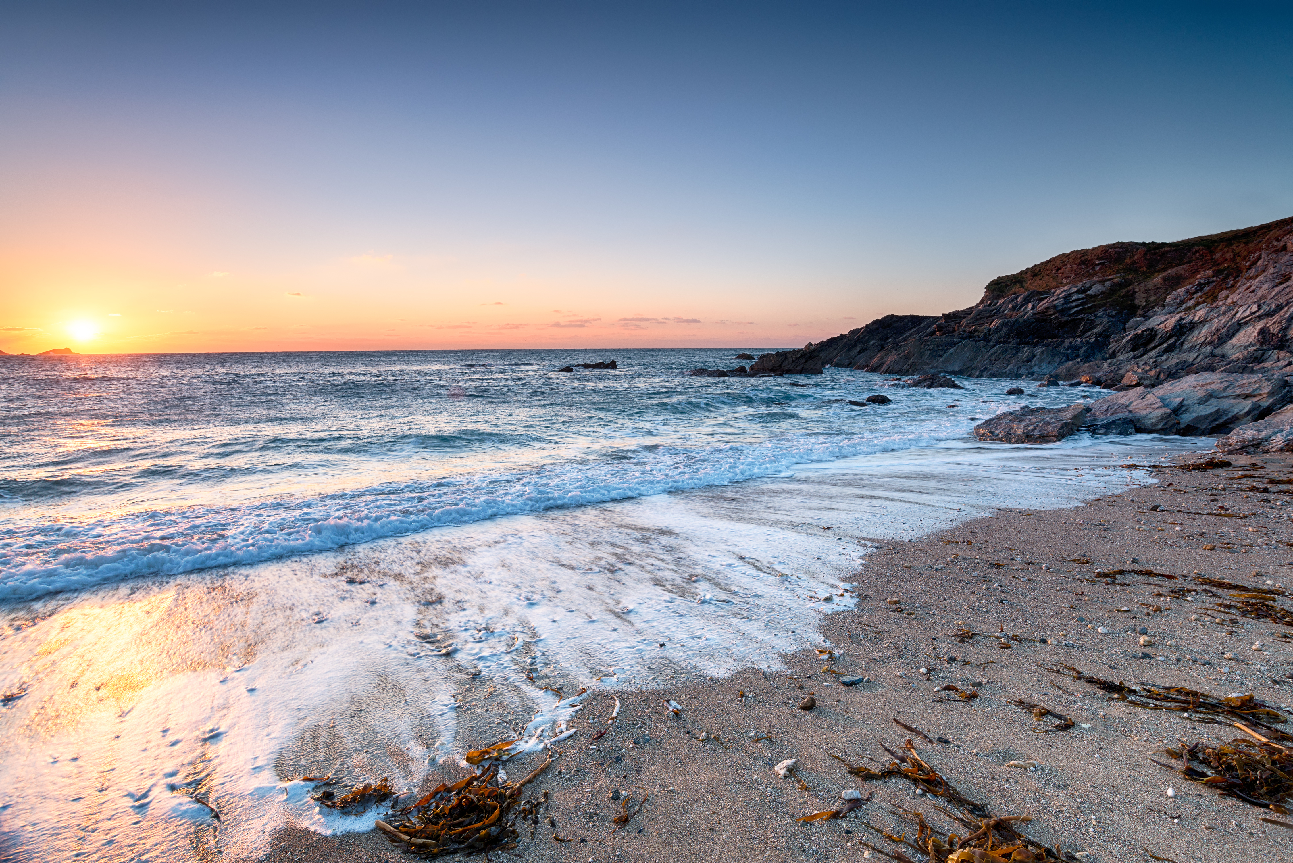 Malerisk solnedgang over Little Fistral Beach med dramatisk himmel og kystlinje ved Towan Headland i Newquay, Cornwall