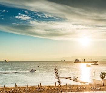 Magisk solnedgang over Det Røde Havs kystlinje ved Aqaba i Jordan med gyldent lys reflekteret i vandet