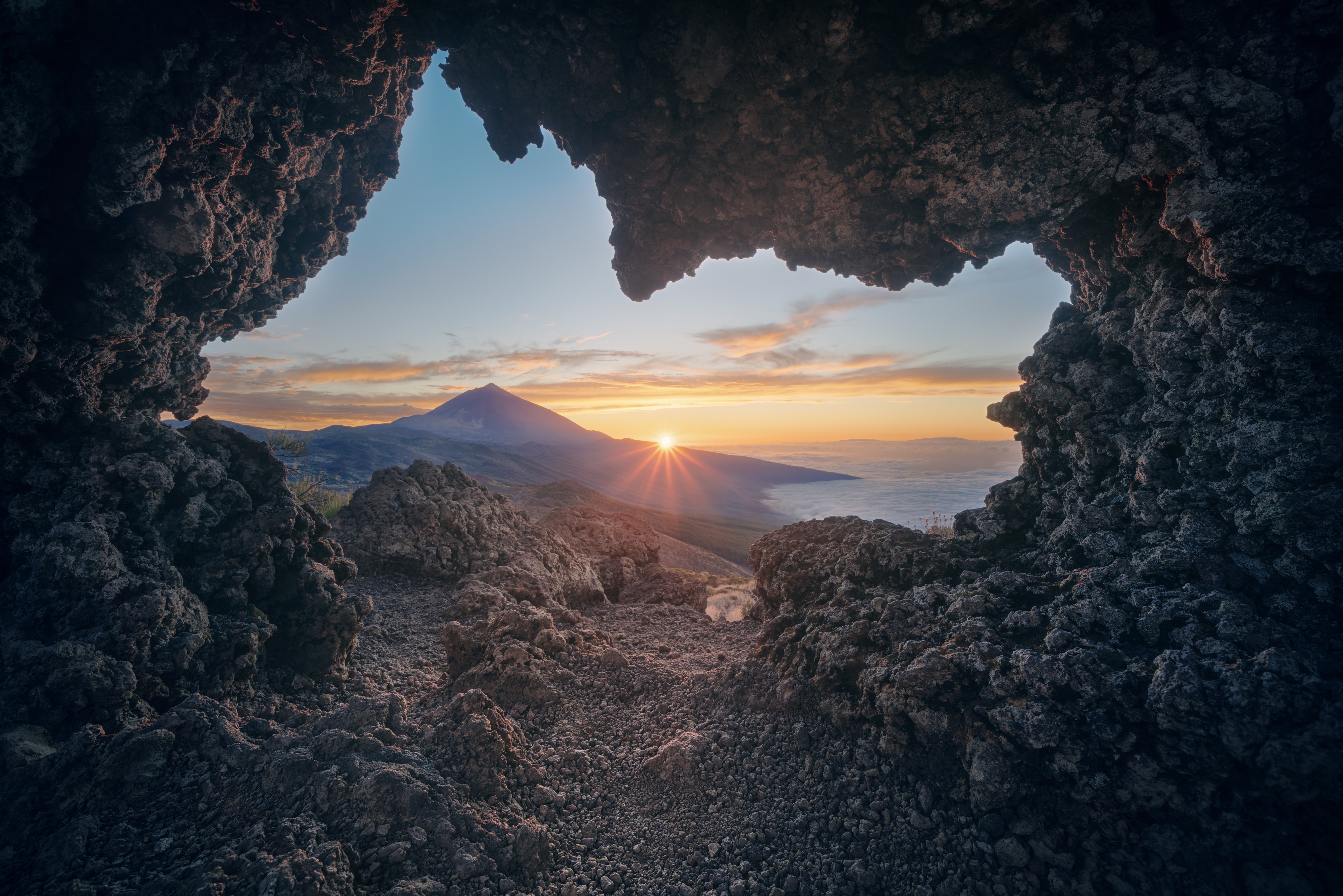 Betagende solnedgang over Teide vulkanen på Tenerife med orange himmel, vulkansk landskab og havudsigt i nationalparken på De Kanariske Øer