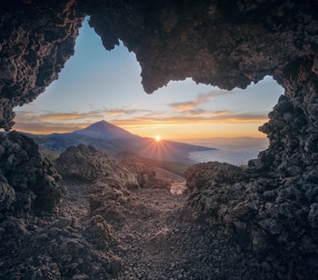 Betagende solnedgang over Teide vulkanen på Tenerife med orange himmel, vulkansk landskab og havudsigt i nationalparken på De Kanariske Øer