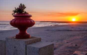Smuk solnedgang over kystbyen Vila Praia de Ancora i Nordportugal med rødgyldent lys over havet og stranden