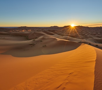 Magisk solopgang over gyldne sandklitter i Sahara-ørkenen nær Merzouga i Marokko, del af vores rundrejse
