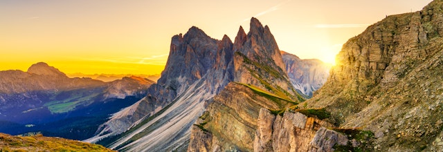 Magisk solopgang over Seceda-toppen i Dolomitterne med gyldne solstråler der oplyser det dramatiske bjerglandskab i Sydtyrol, Italien