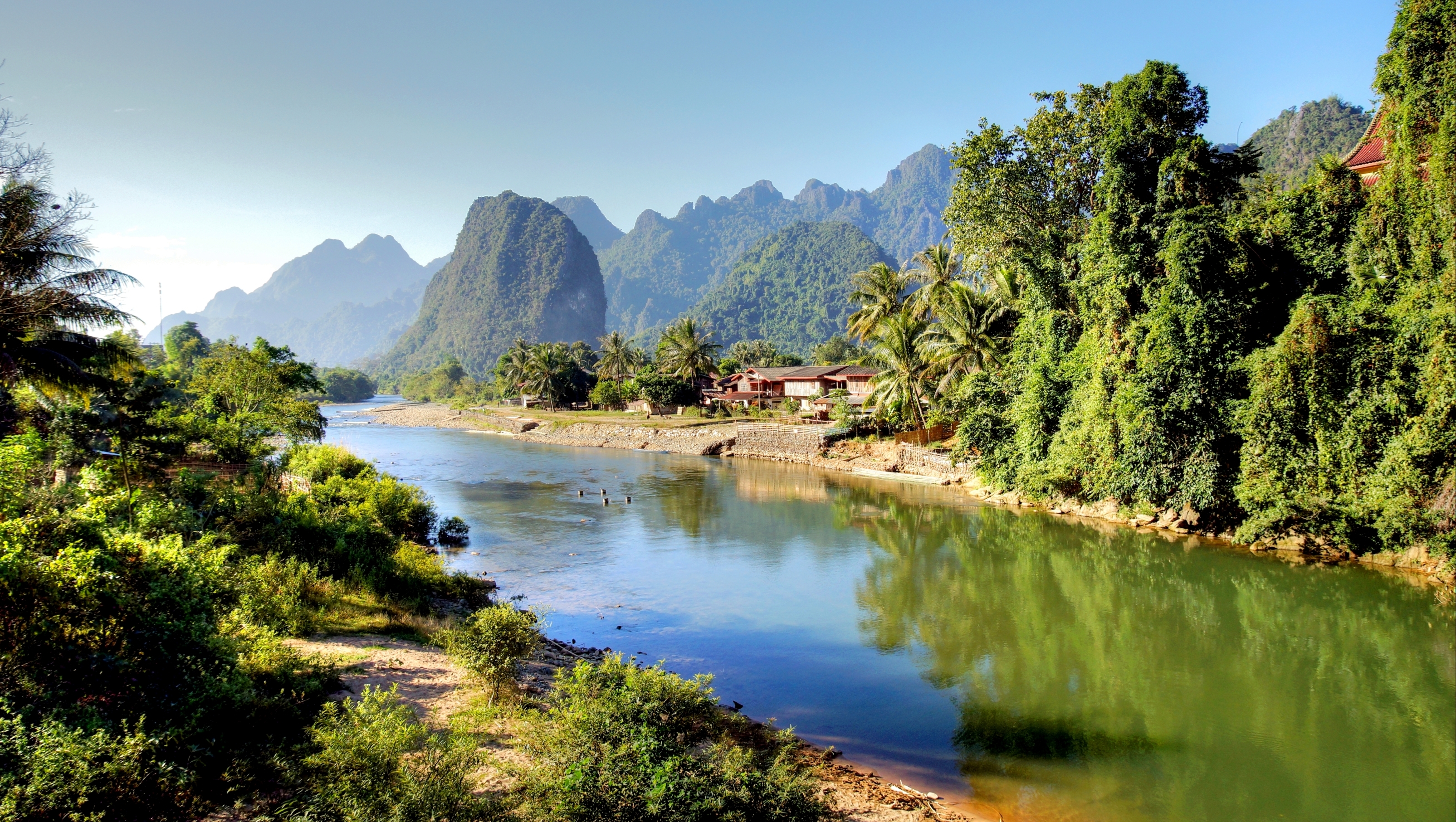 Idyllisk udsigt over Song-floden med majestætiske kalkstensformationer i Vang Vieng, Laos - et perfekt rejsemål for naturelskere
