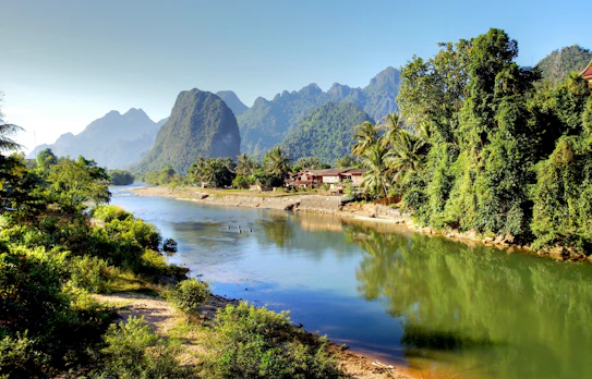 Idyllisk udsigt over Song-floden med majestætiske kalkstensformationer i Vang Vieng, Laos - et perfekt rejsemål for naturelskere