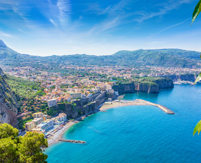 Luftfoto af Sorrentos dramatiske klippekyst med udsigt over den blå Napoli-bugt og saftige gule citroner i forgrunden, kendt for produktionen af limoncello i Italien