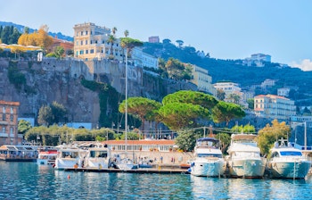 Luksuriøse både i Sorrentos maleriske marina med klippe-bygninger og Middelhavskyst