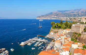 Malerisk udsigt over Sorrento med farverige bygninger, blåt hav og den karakteristiske kystlinje langs Amalfikysten i Italien