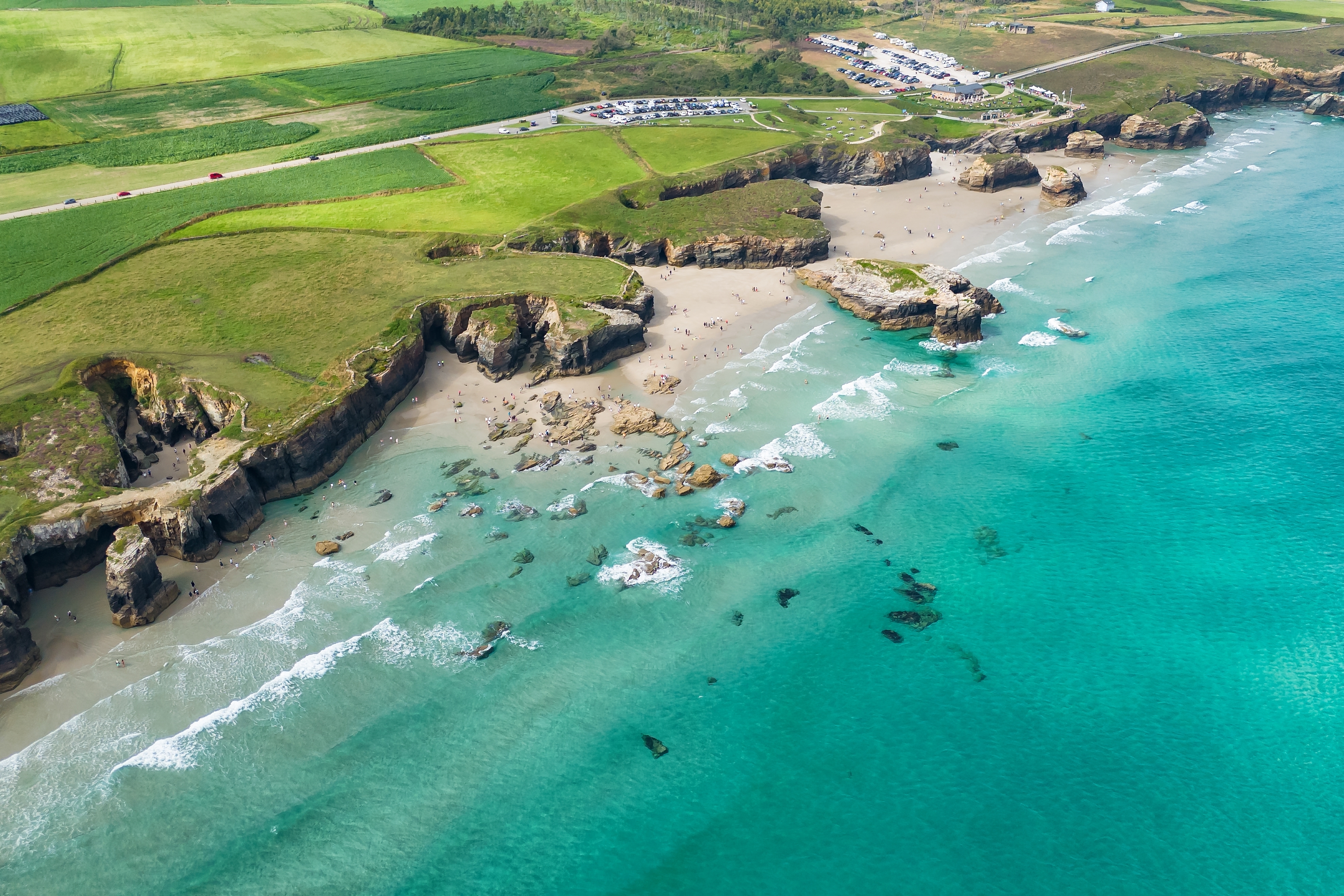 Spektakulært luftfoto af smaragdgrøn Atlanterhavskyst med dramatiske klipper og sandstrande i Galicia Spanien