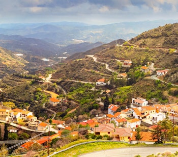 Pittoresk spansk bjerglandsby med orange teglstenstage i grøn dal med bjergudsigt