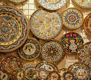 Farverige håndlavede spanske keramiktallerkener med traditionelle mønstre, som kan købes som souvenirs på markeder langs Caminoen