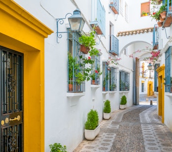 Charmerende hvide gader med farverige døre og blomsterkrukker i traditionel spansk by
