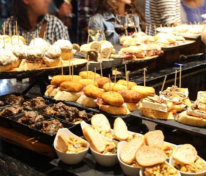 Farverige spanske tapas og pinchos - traditionelle appetitvækkere serveret i cocktailtimen på en autentisk tapasbar i Spanien