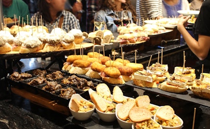 Farverige spanske tapas og pinchos - traditionelle appetitvækkere serveret i cocktailtimen på en autentisk tapasbar i Spanien