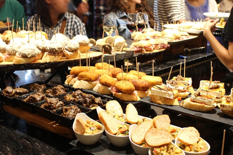 Farverige spanske tapas og pinchos - traditionelle appetitvækkere serveret i cocktailtimen på en autentisk tapasbar i Spanien