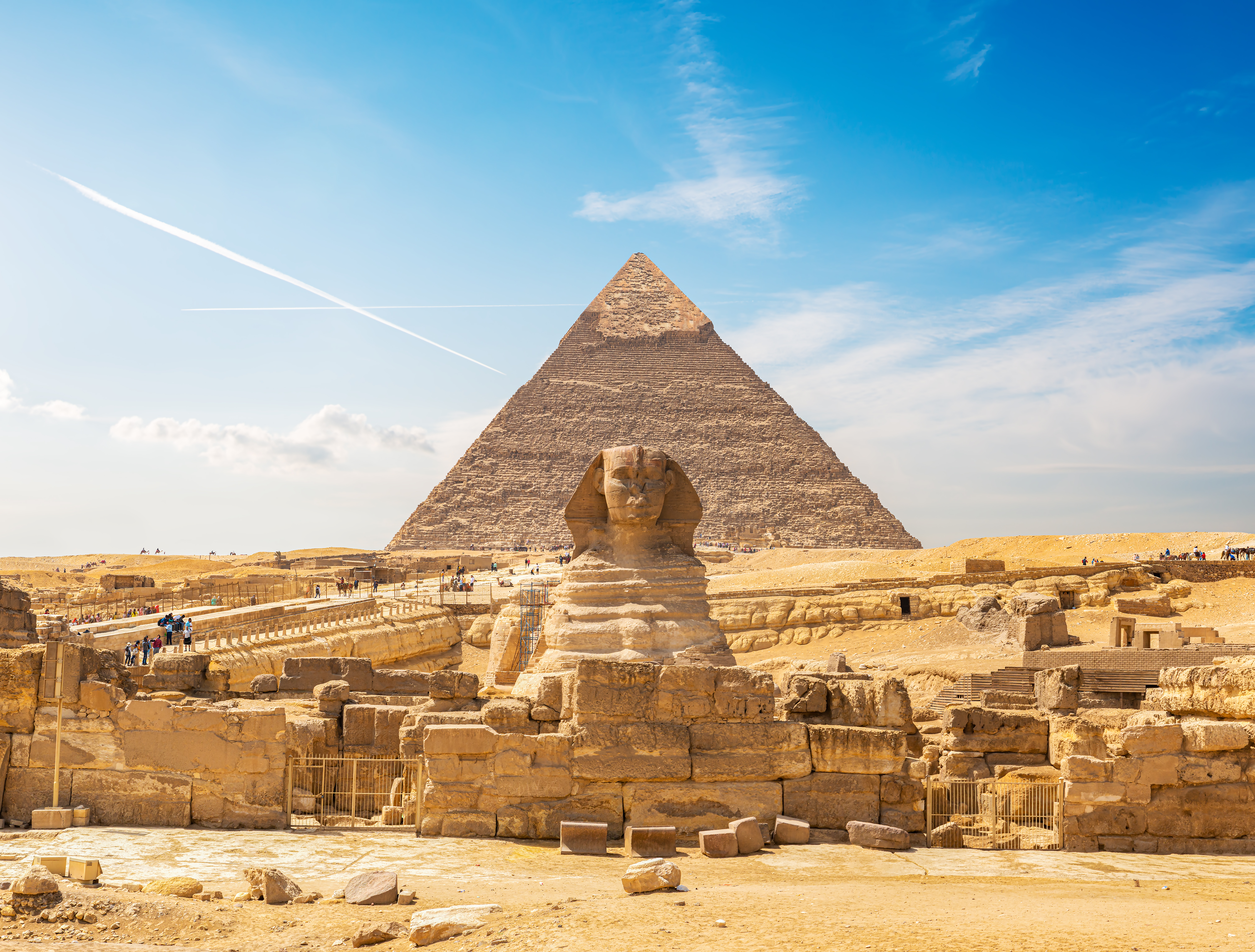 Den store Sphinx i Giza med Khafres pyramide i baggrunden under en klar blå himmel i den egyptiske ørken