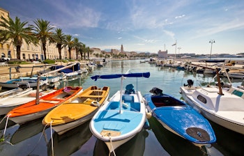 Farverig udsigt over Splits havn med traditionelle fiskerbåde og historisk arkitektur langs den kroatiske kyst