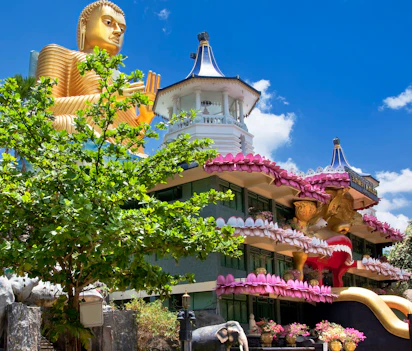 Gylden Buddha statue ved buddhistisk tempel i Sri Lanka med lotus dekorationer