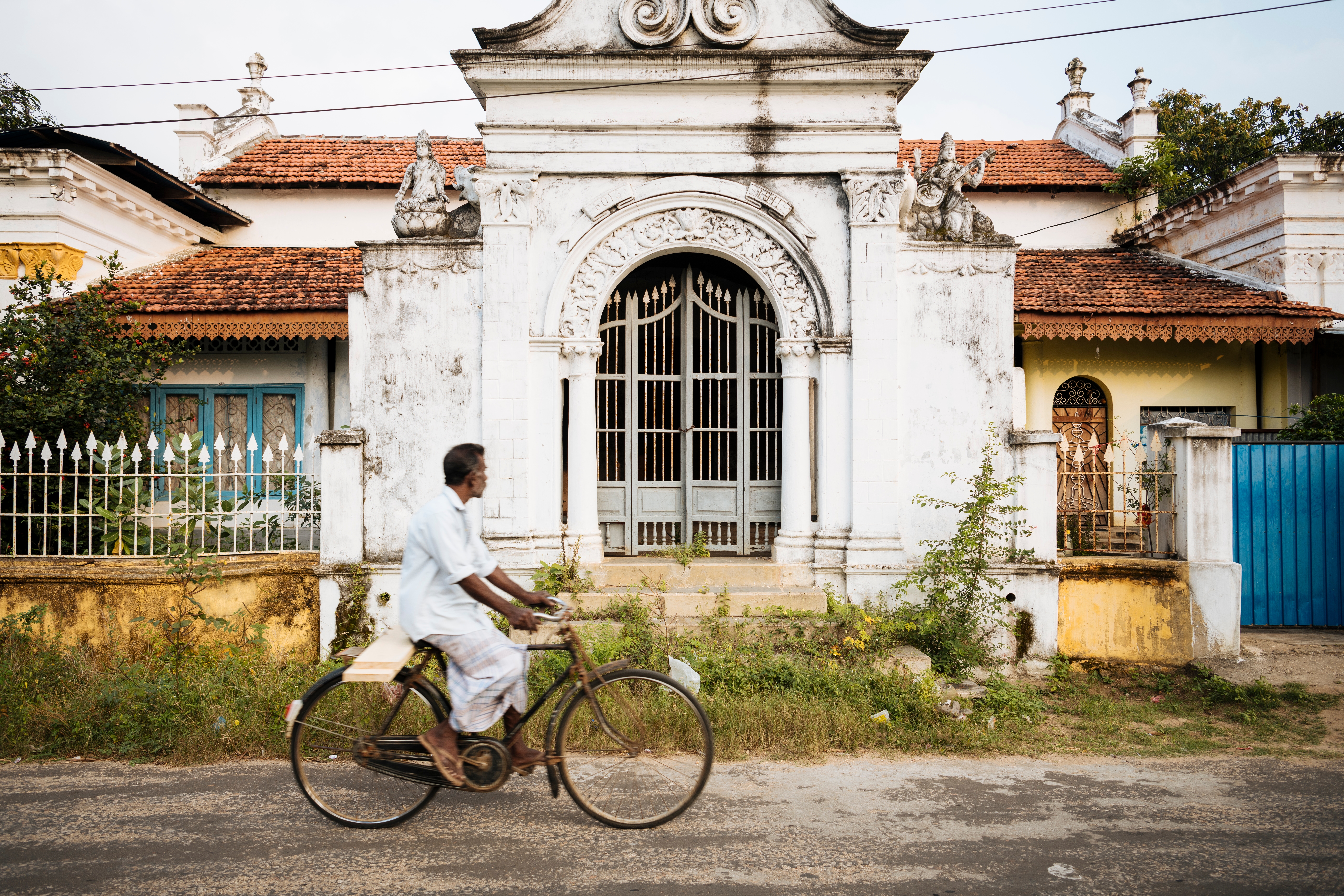 Lokal mand cykler forbi kolonial arkitektur i Jaffna, Sri Lanka