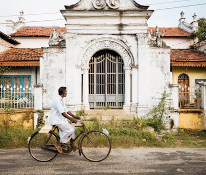 Lokal mand cykler forbi kolonial arkitektur i Jaffna, Sri Lanka