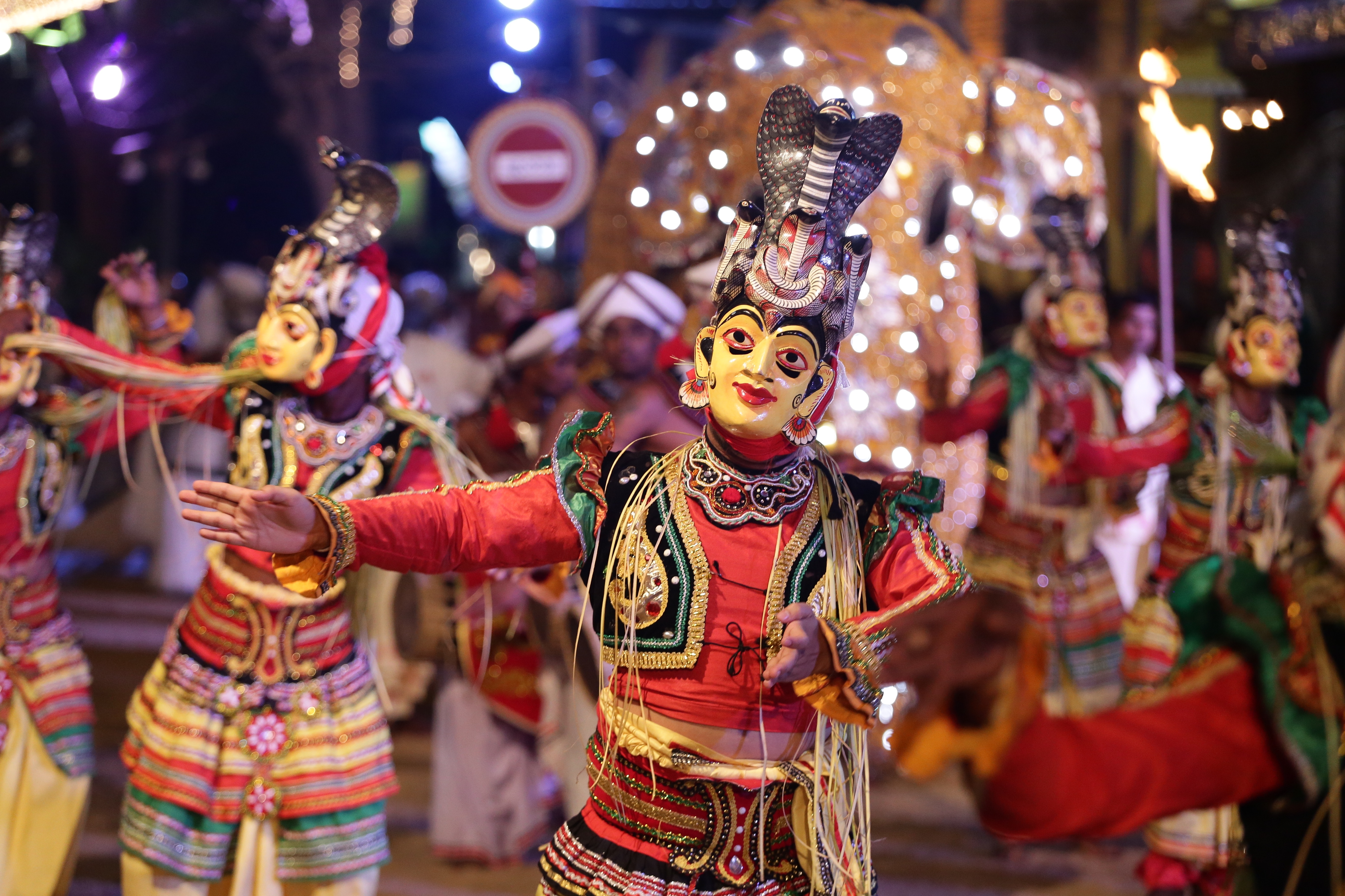 Farvestraalende srilankanske traditionelle dansere i flotte kostumer optraeder under den aarlige Katharagama Perahera festival, der viser Sri Lankas rige kulturarv og ceremonielle dansetraditioner