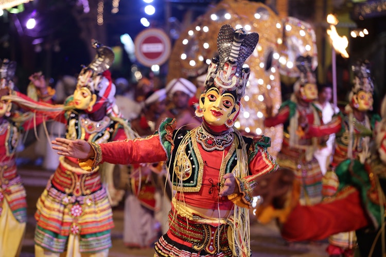 Farvestraalende srilankanske traditionelle dansere i flotte kostumer optraeder under den aarlige Katharagama Perahera festival, der viser Sri Lankas rige kulturarv og ceremonielle dansetraditioner