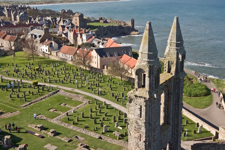 Historiske ruiner af St Andrews Katedral med udsigt over den skotske kystby og det blå hav