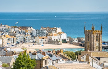 Panoramaudsigt over St. Ives i Cornwall med historiske tage, havneområde og den smukke kyststrækning ved den engelske kanalby