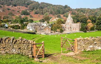 Den historiske St. Peters Kirke i Finsthwaite landsby, omgivet af grønne bakker i Cumbria, England nær Lake District