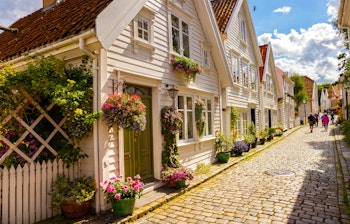 Historiske hvide træhuse med blomster langs brostensgade i Gamle Stavanger Norge