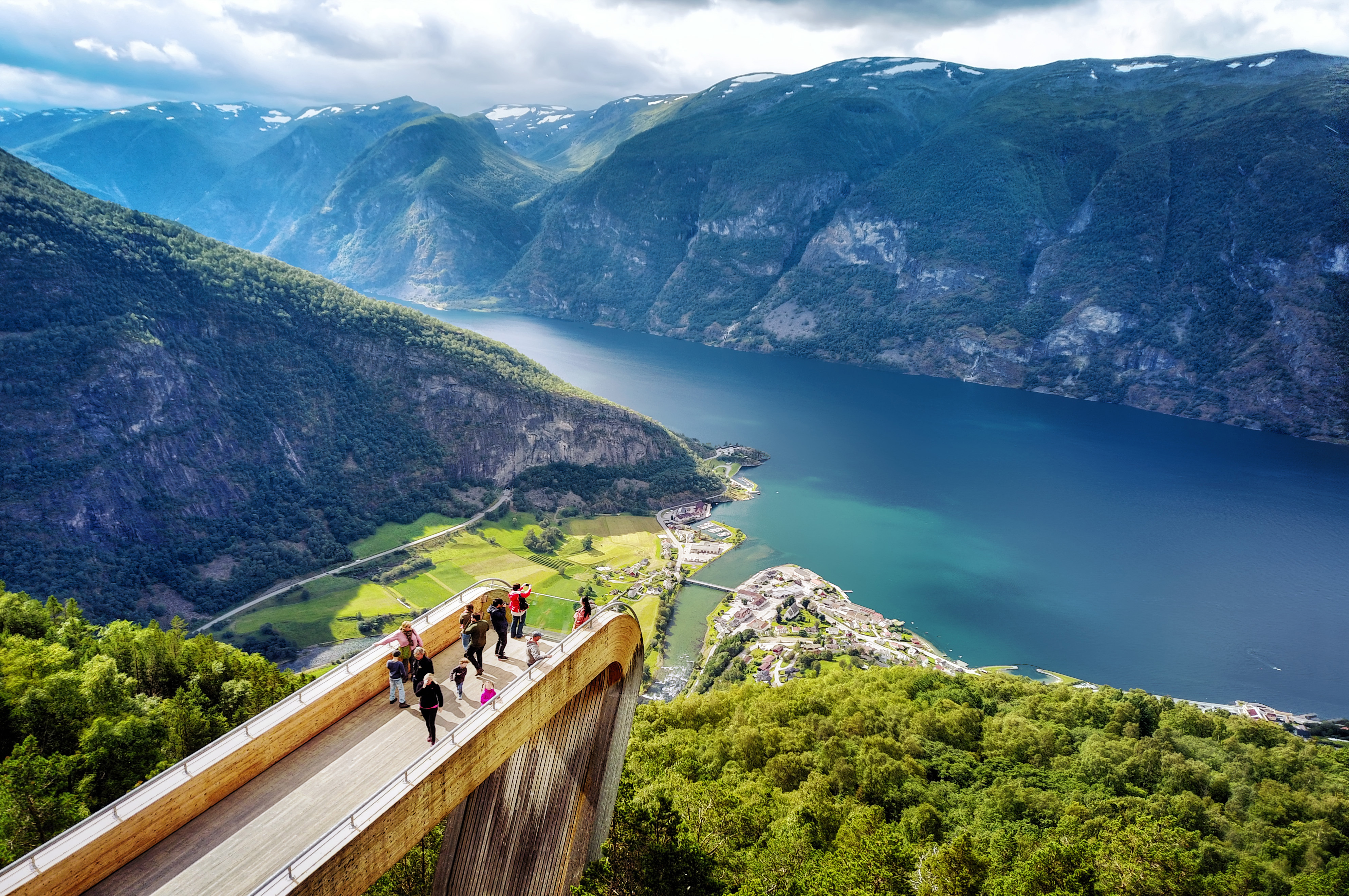 Turister på den ikoniske Stegastein udsigtsplatform med spektakulær udsigt over Aurlandsfjorden og de norske fjelde