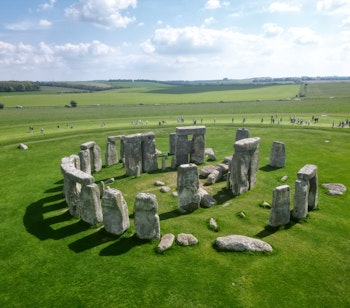 Betagende dronefoto af Stonehenge, den ikoniske stencirkel fra 3000 f.Kr., omgivet af det grønne Wiltshire-landskab i England - et UNESCO verdensarvssted