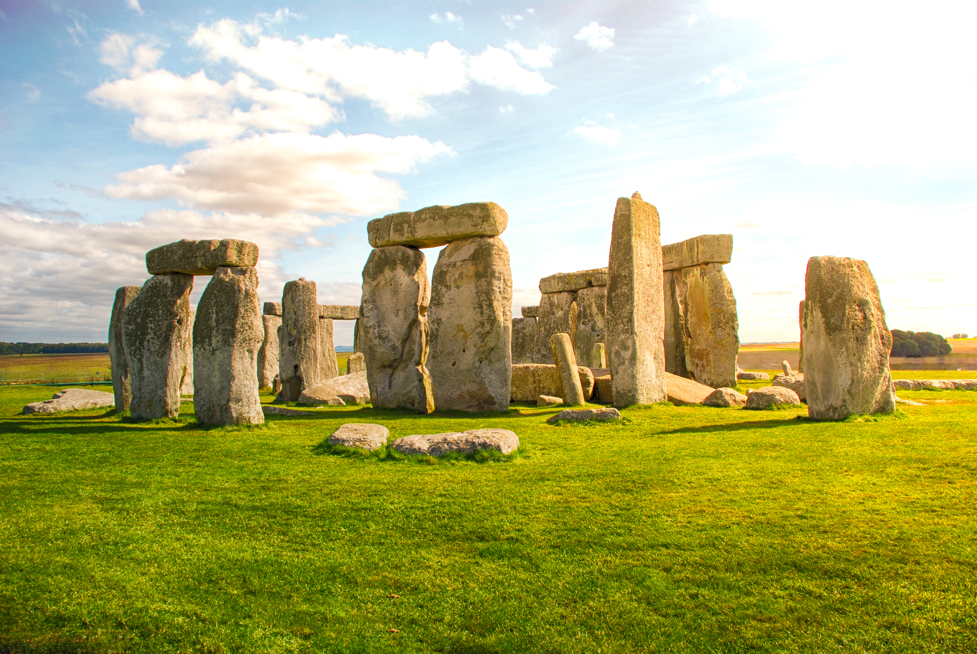 Det historiske Stonehenge monument i Wiltshire, England badet i gyldent solnedgangslys med dramatisk himmel over de ældgamle stencirkler