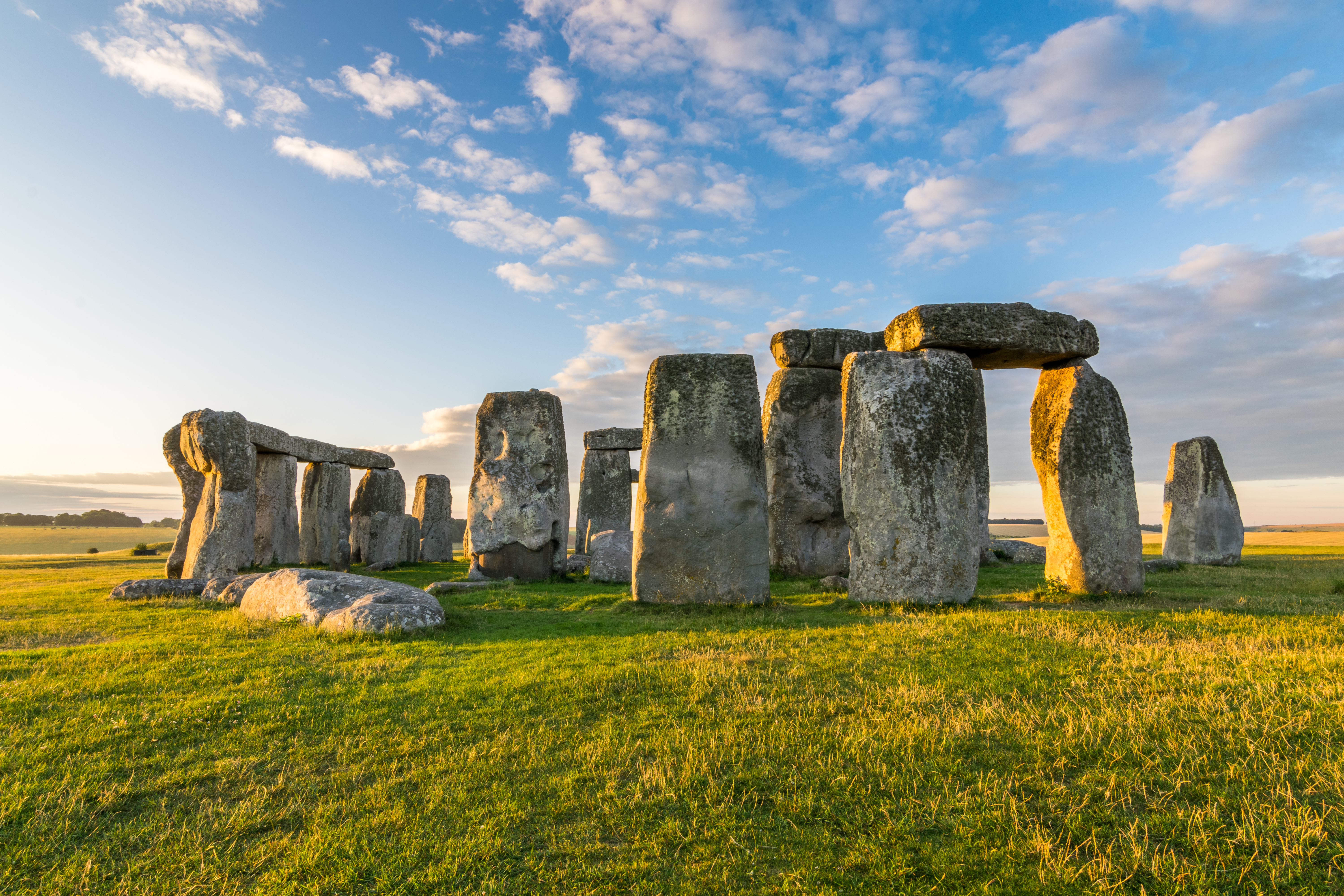 Det majestætiske Stonehenge på Salisbury-sletten i England, hvor de gamle megalitsten bades i gyldent sollys under en blå himmel