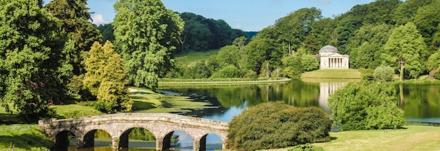 Den historiske Palladian-bro spejler sig i den rolige sø i Stourhead Garden, en af Englands mest berømte landskabshaver i Wiltshire