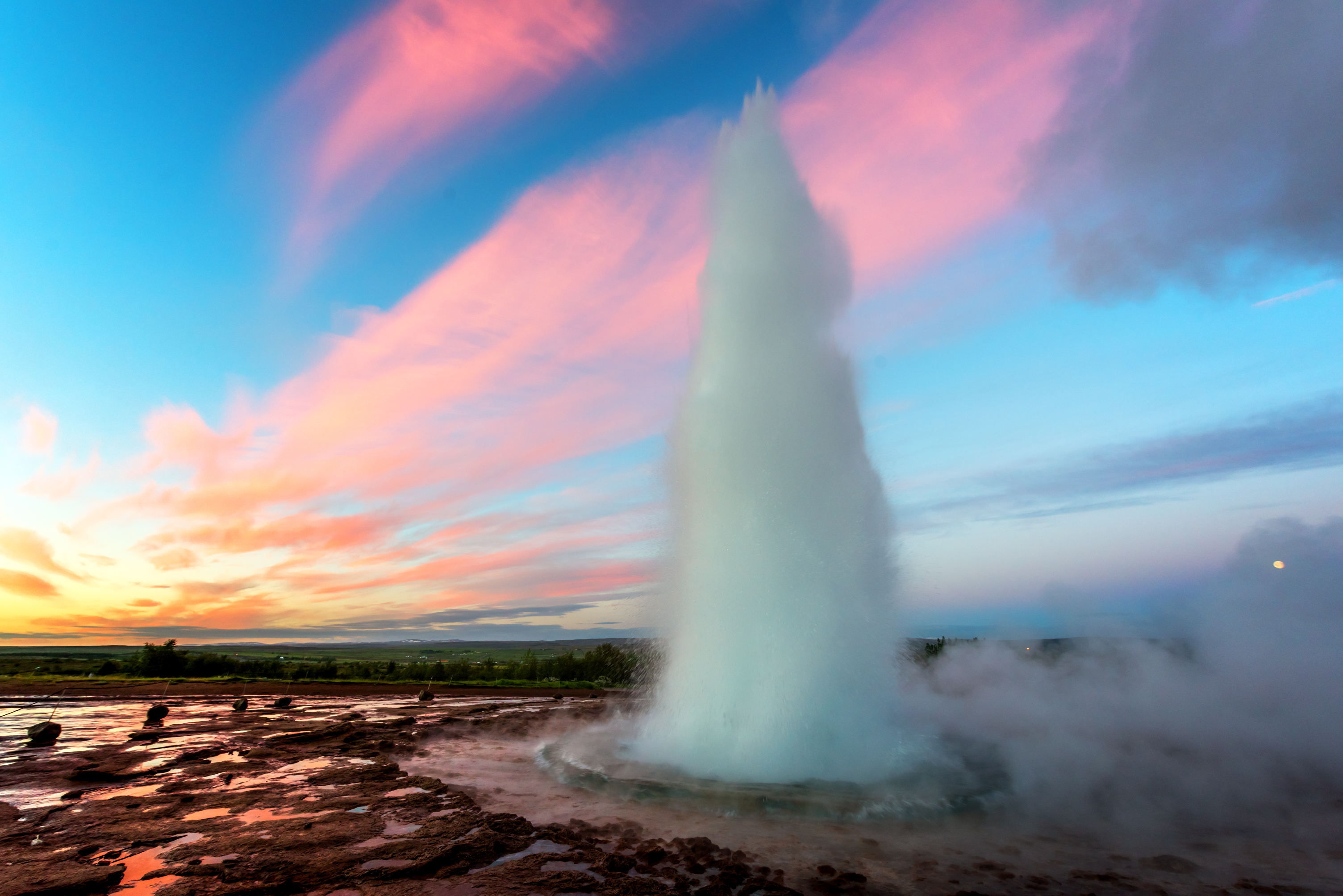 Strokkur gejser der sprøjter ved solnedgang på Island