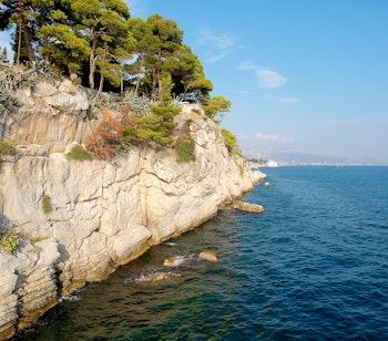 Smuk udsigt fra Sustipan-parken i Split med klippevæg, middelhavs-vegetation og det azurblå Adriaterhav