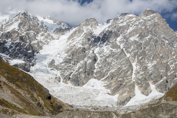 Betagende efterårslandskab i Svaneti-regionen i Georgien med sneklædte Kaukasus-bjerge, gyldne træer og klar blå himmel