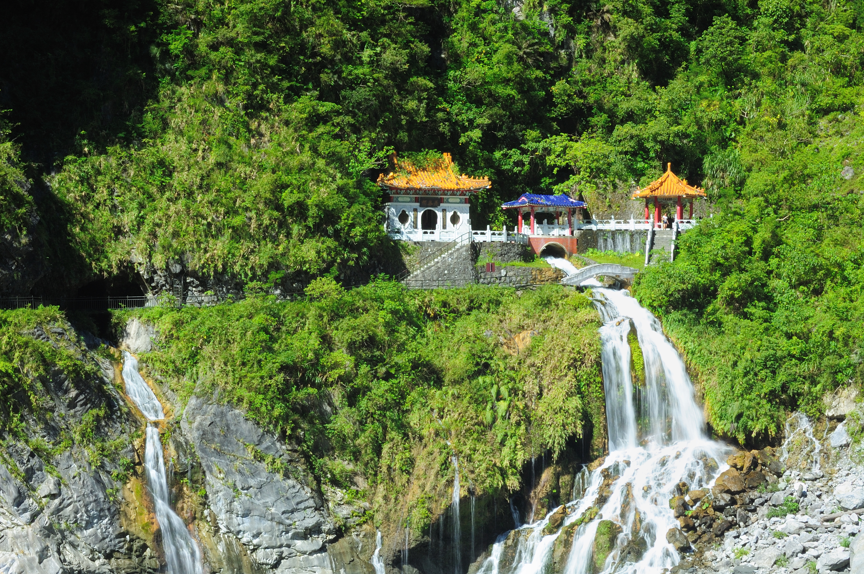 Traditionel kinesisk pavillon med gyldne tage ved imponerende vandfald i Taroko Nationalpark Taiwan
